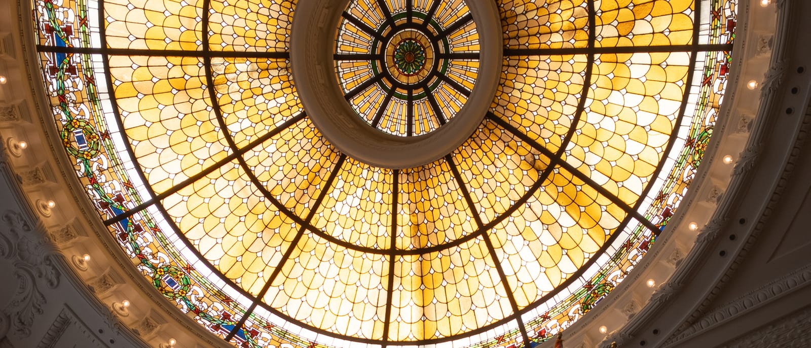 Stained-glass dome and a row of flags inside the Alex. Brown & Sons Building in Baltimore, seen from the floor below.